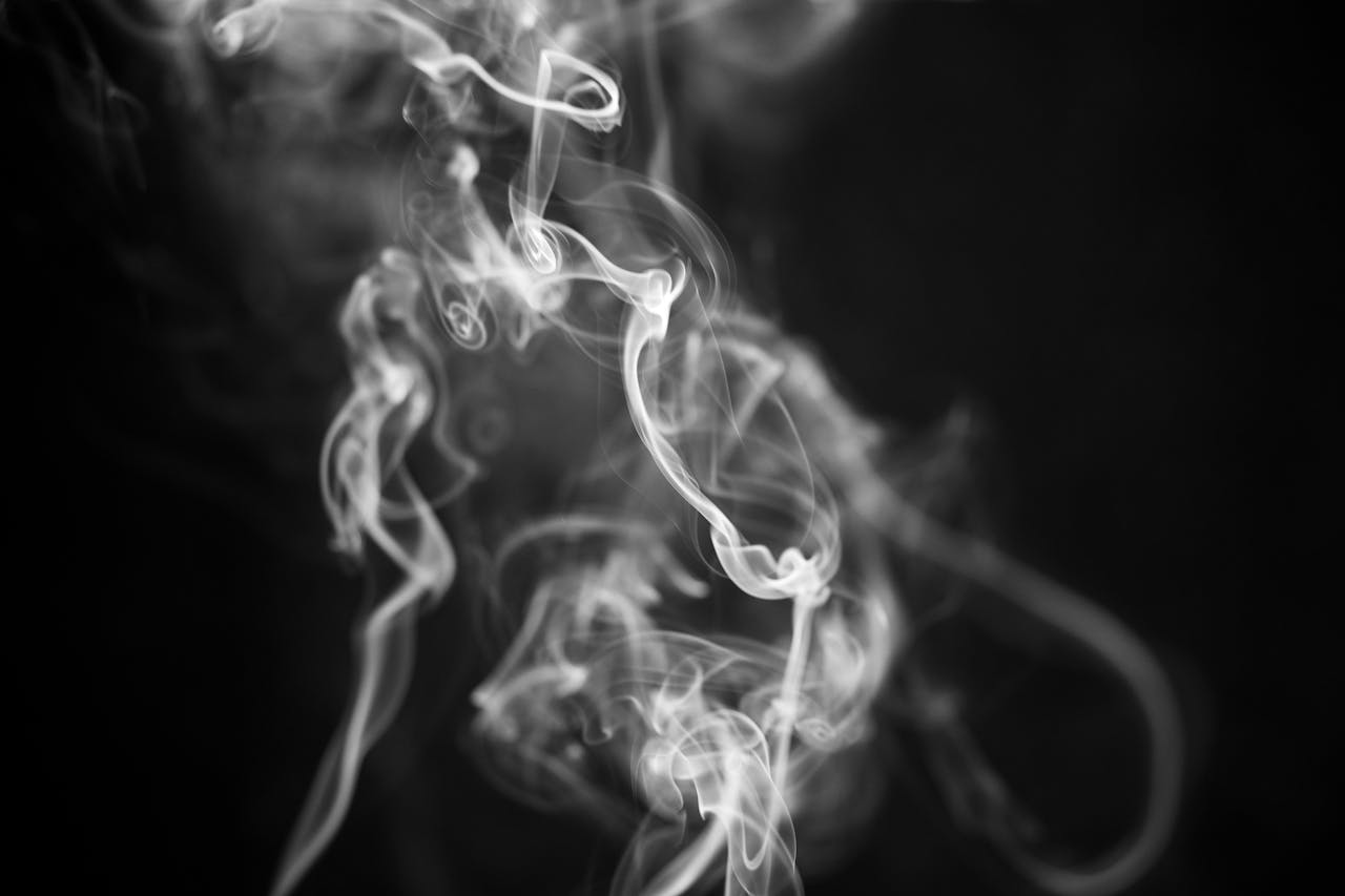Abstract close-up of swirling white smoke on a black background, capturing ethereal movement.